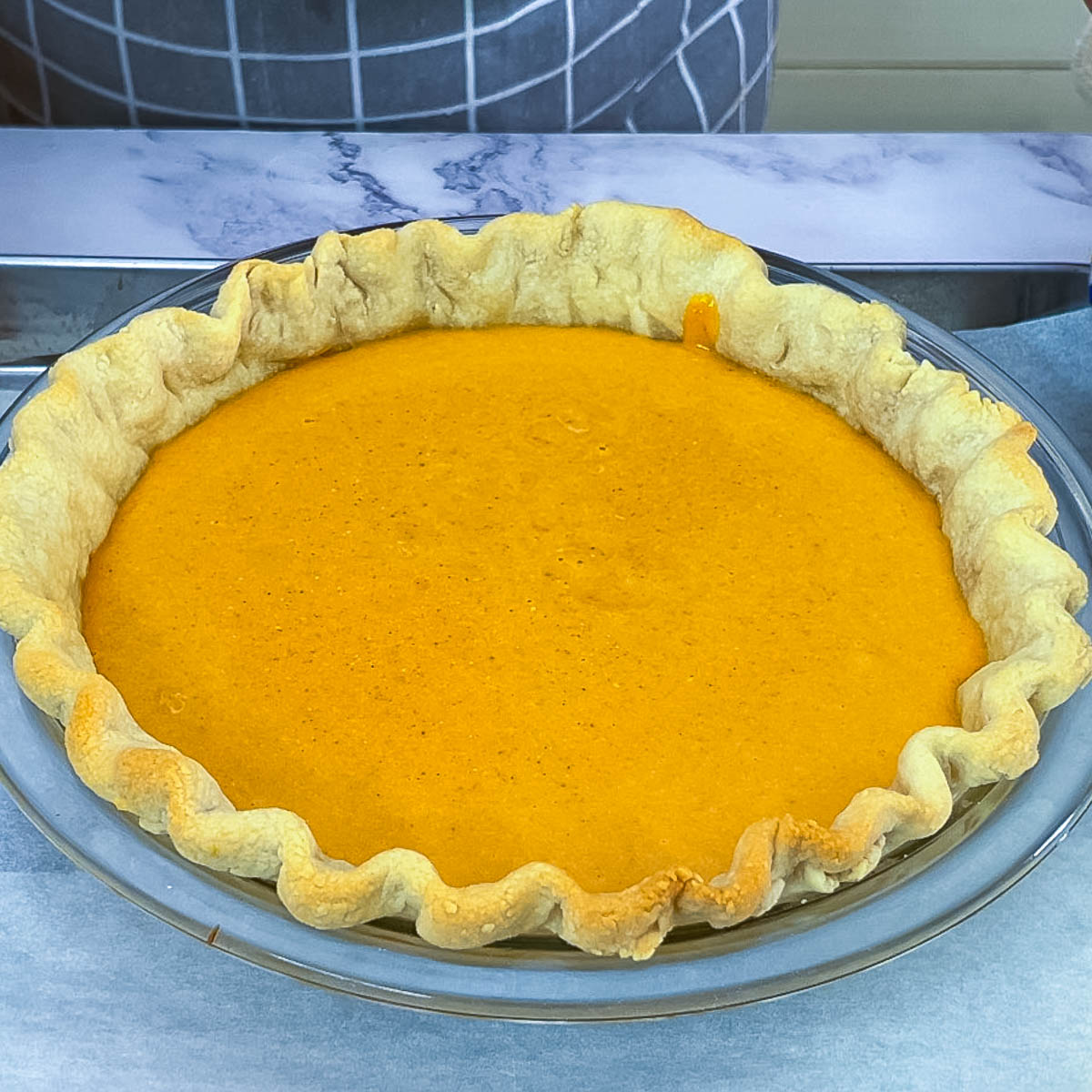 Partially baked pie crust with pumpkin pie filling.