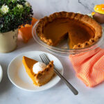 A baked pumpkin pie in pie pan.