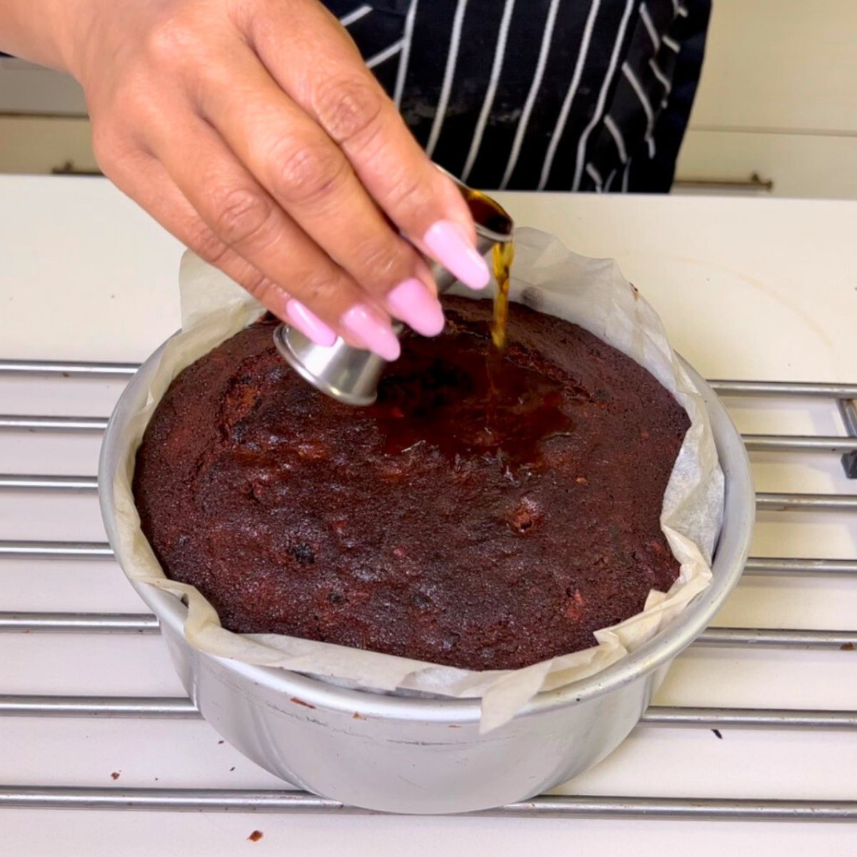 Pouring rum on a freshly baked fruitcake.