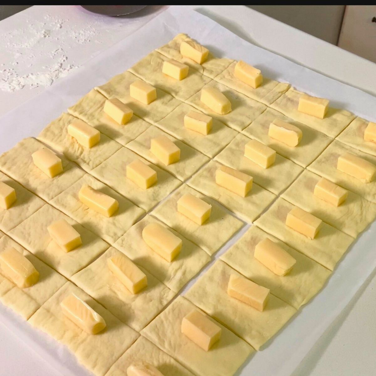 Pizza dough pieces with cheese cubes.