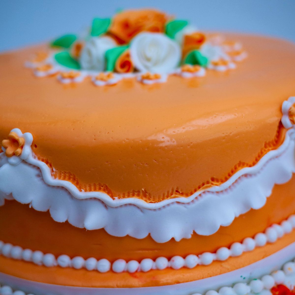 Single-tier fruitcake wedding cake with fondant roses and crimped sides.