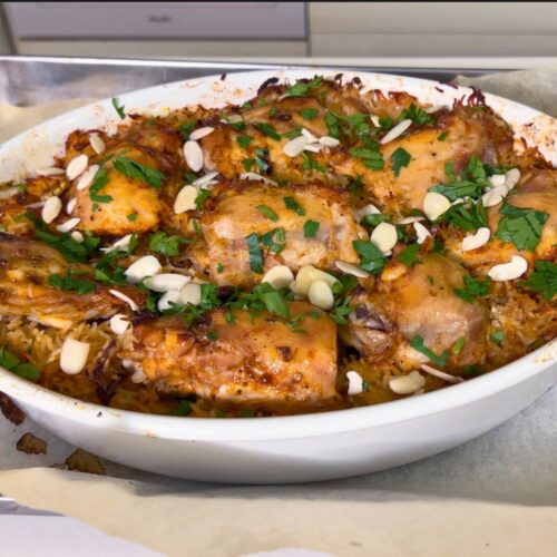 Baked chicken and rice dish in baking pan.