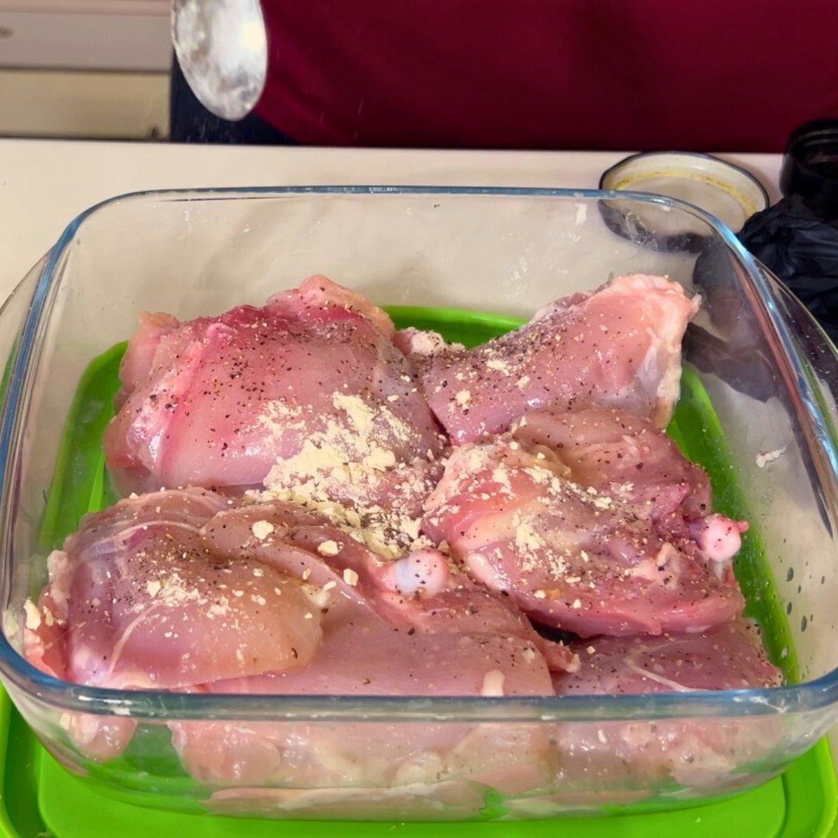 Marinating chicken in a glass dish.