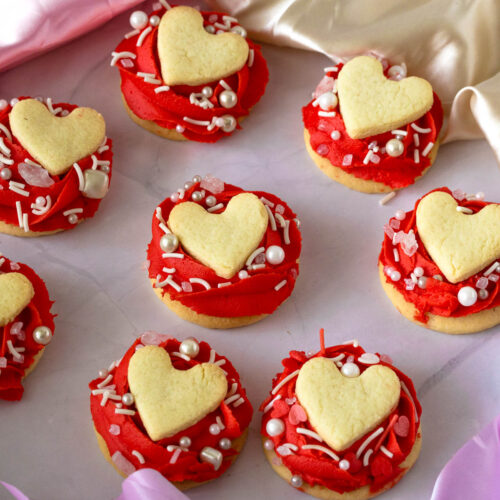 Buttercream Rose Frosted Cookies with Heart Cookies on top.