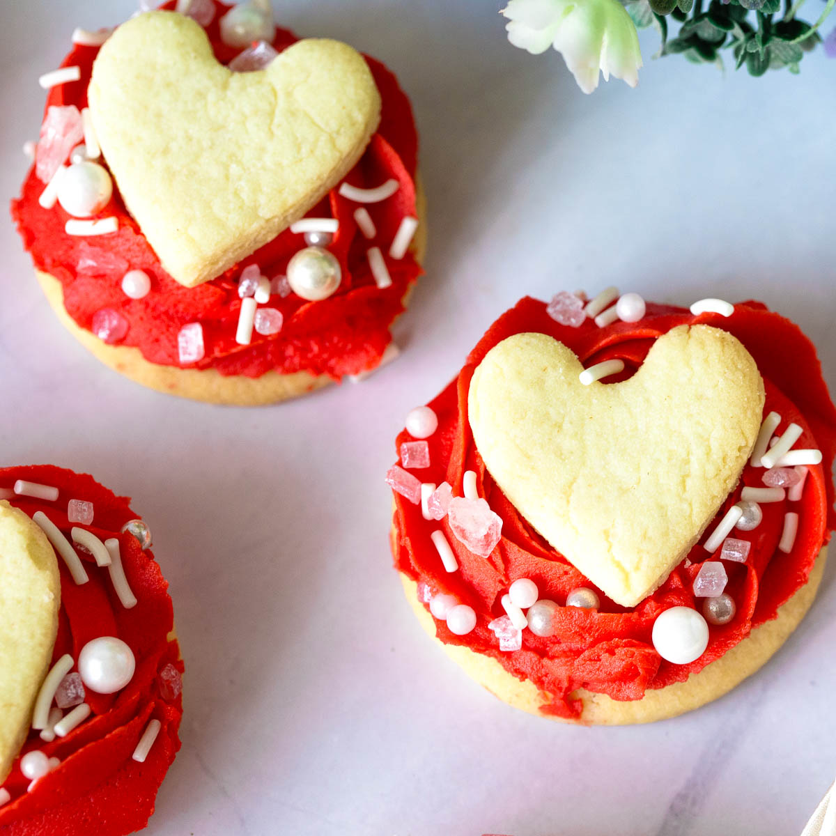 Sugar cookies frosted with buttercream rose on top.