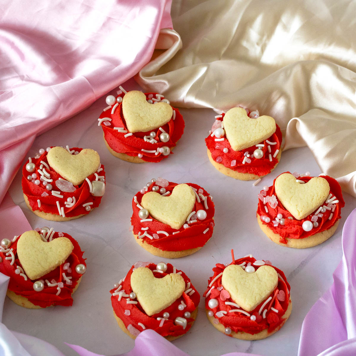 Buttercream Rose Frosted Cookies with heart toppers.