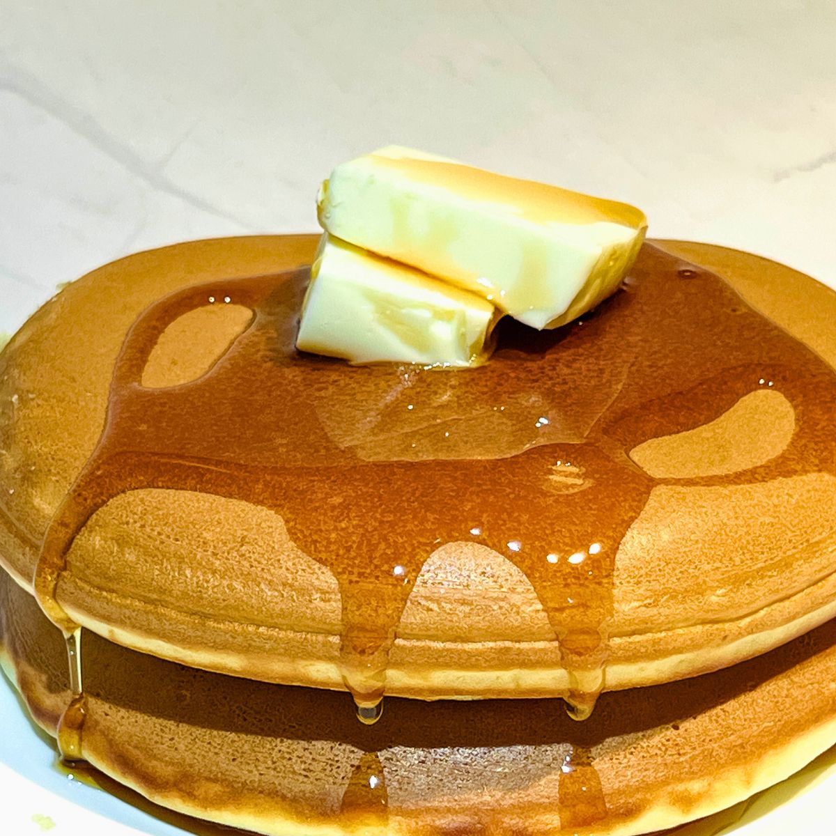 Two fluffy pancakes with butter.