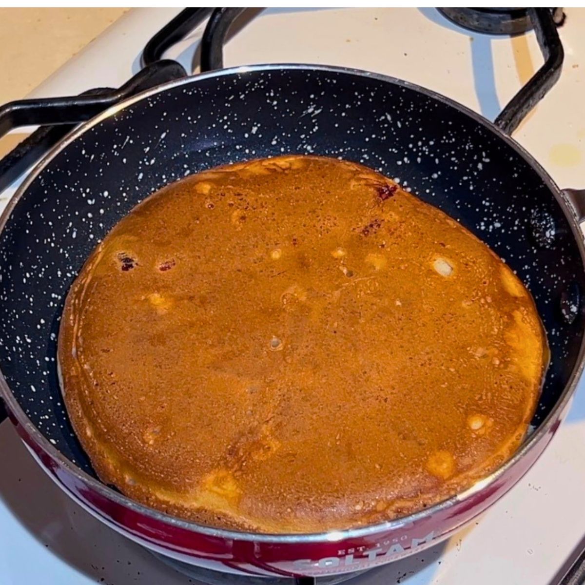 A frying pan with cooked strawberry pancake.