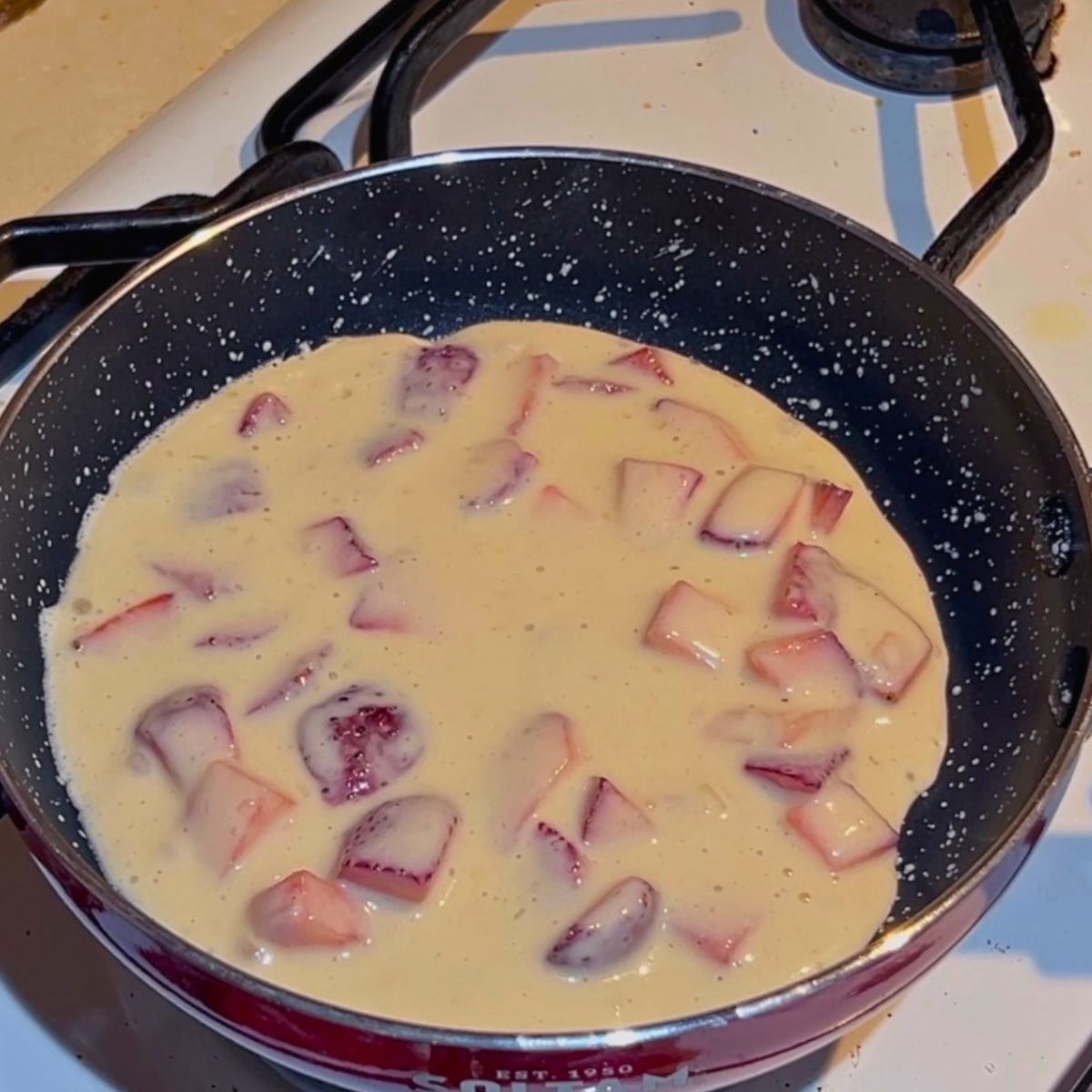 A frying pan with fresh strawberry batter.
