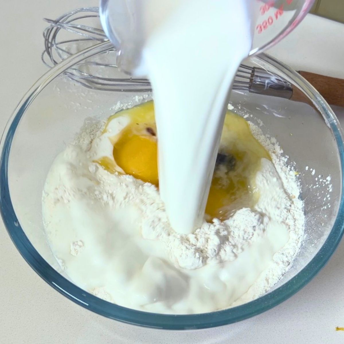 A glass bowl with fresh pancake batter.