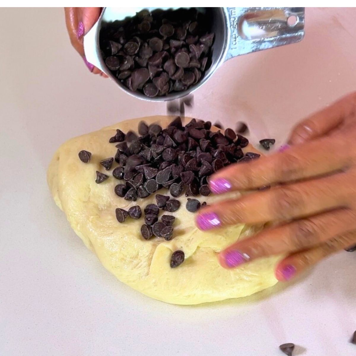 Adding chocolate chips to the sweet dough.