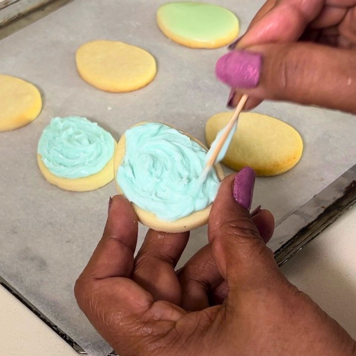 Frosting egg cookies with buttercream.