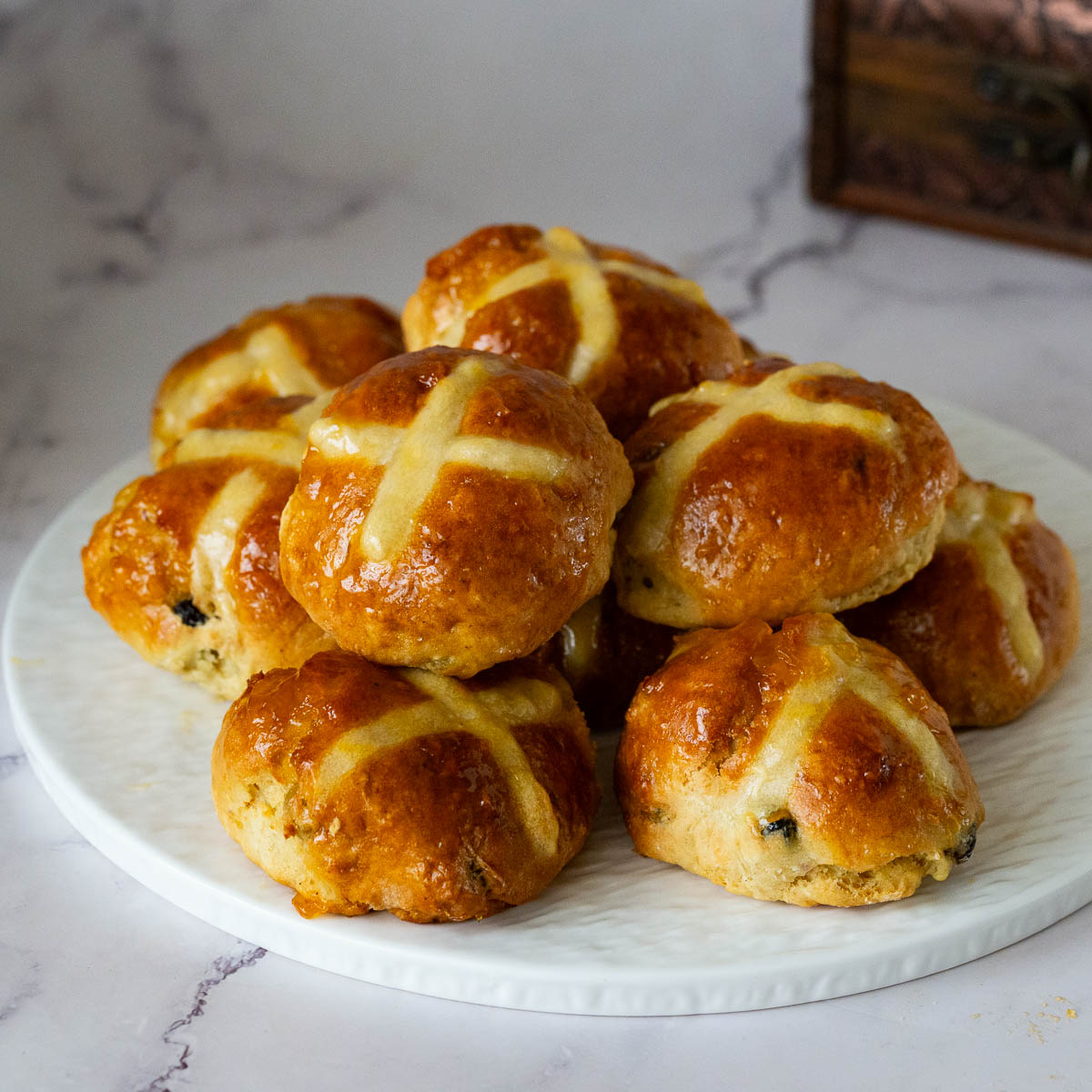 A stack of hot cross buns on the platter.