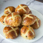 A stack of 30 mins hot cross buns on the table.