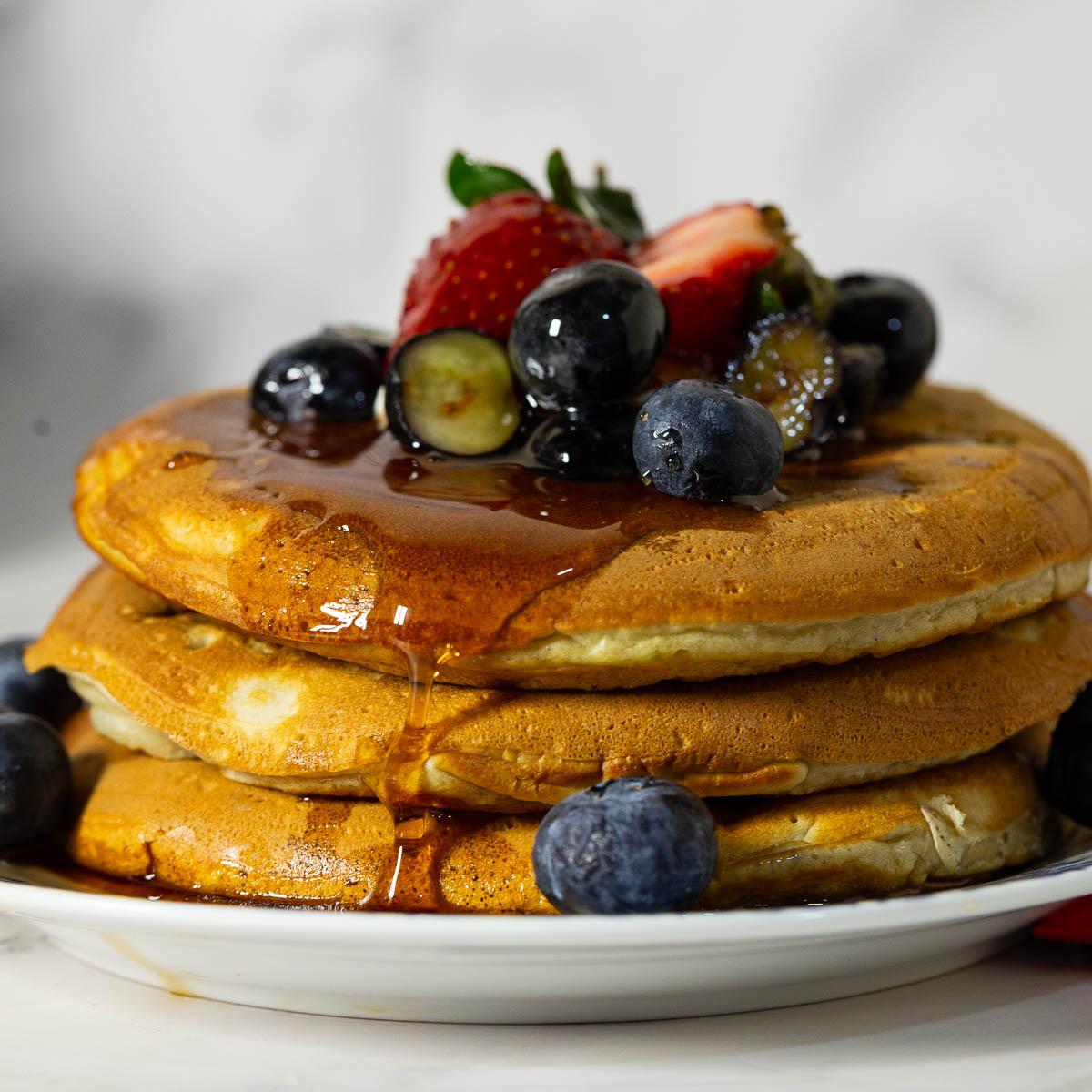 A stack of pancakes with fresh blueberries.