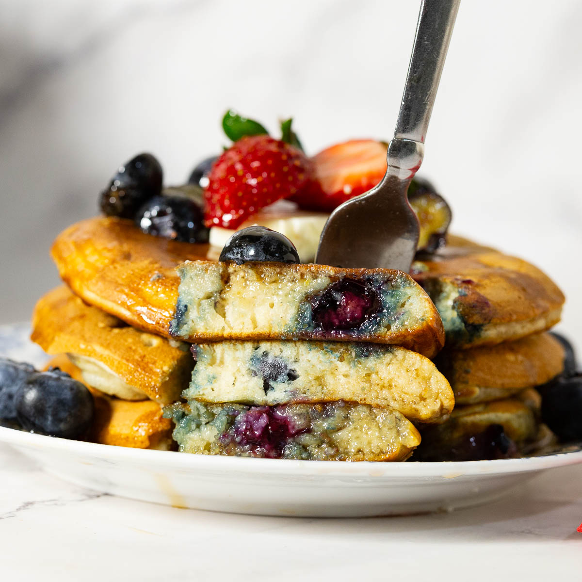 Stack of blueberry pancakes on the plate.