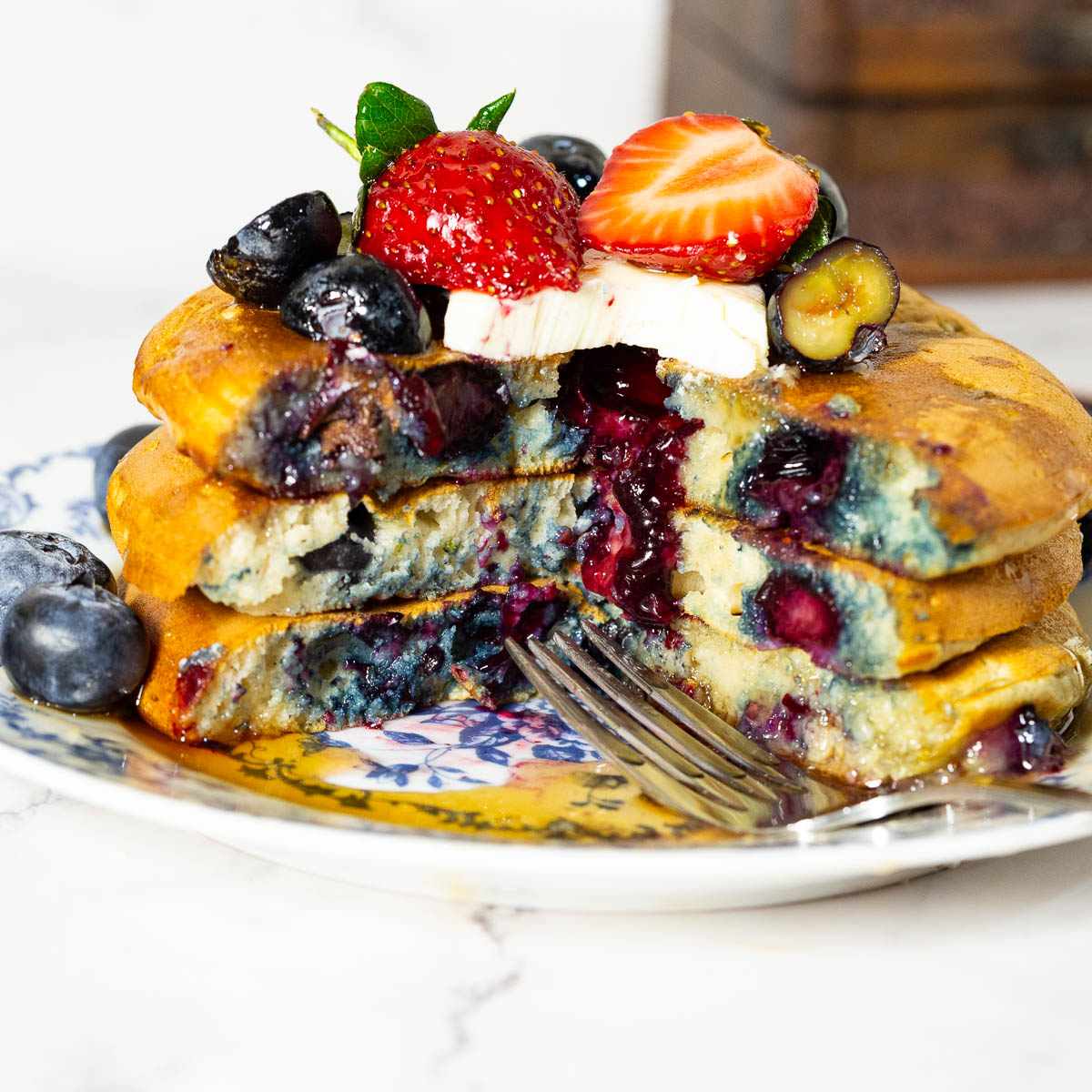 A stack of fresh pancakes on a ceramic plate.