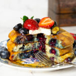 A plate with a stack of fresh blueberry pancakes.