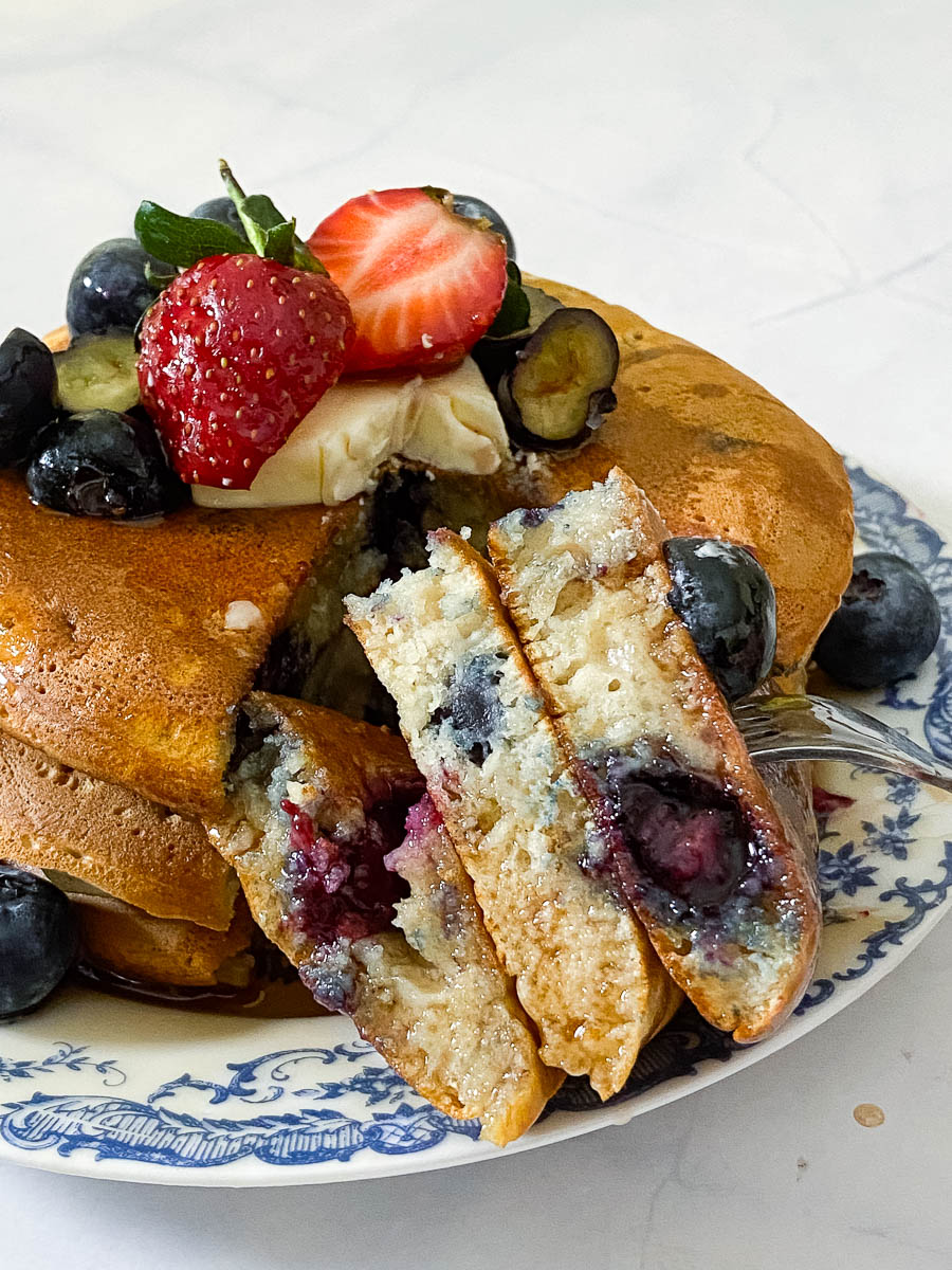 A sliced of stacked blueberry pancakes.