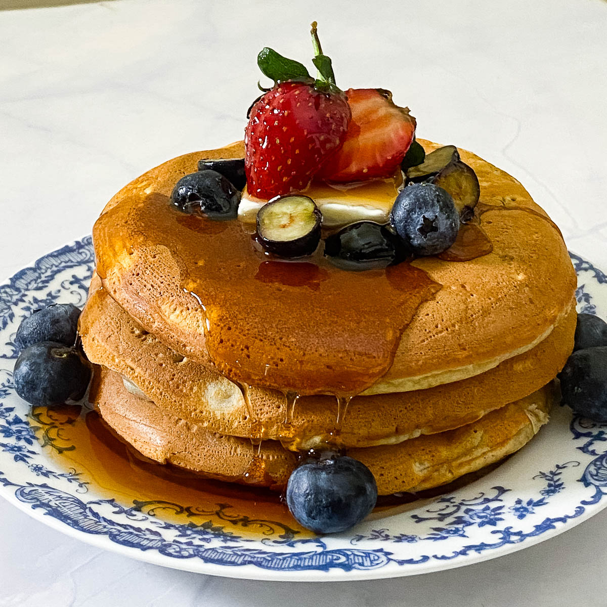 Pancakes stacked on a ceramic plate.