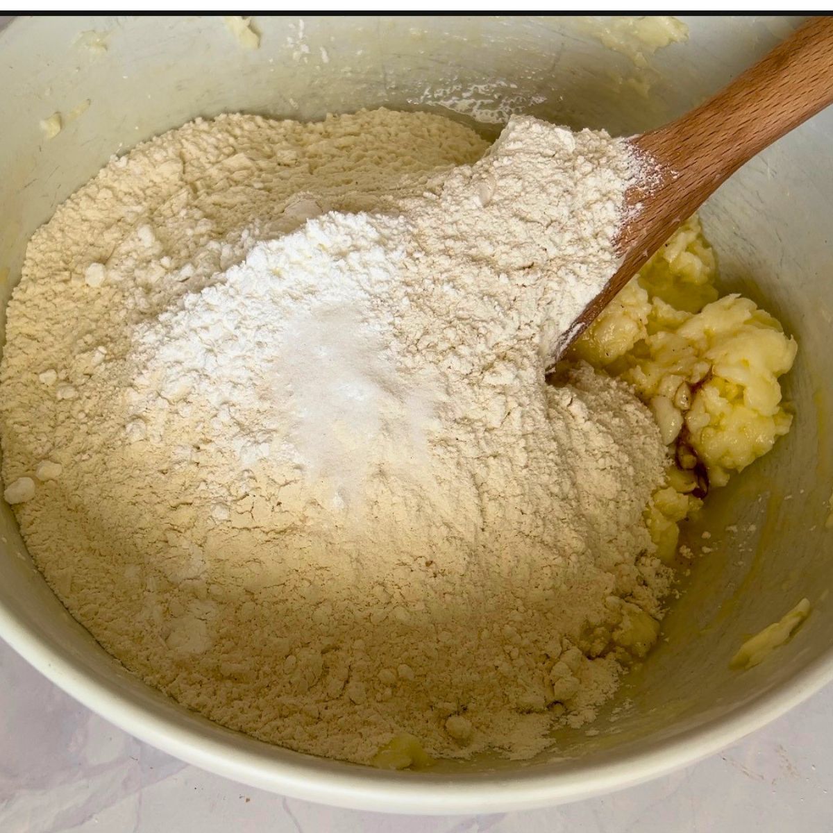 Adding dry ingredients to sugar cookie dough.