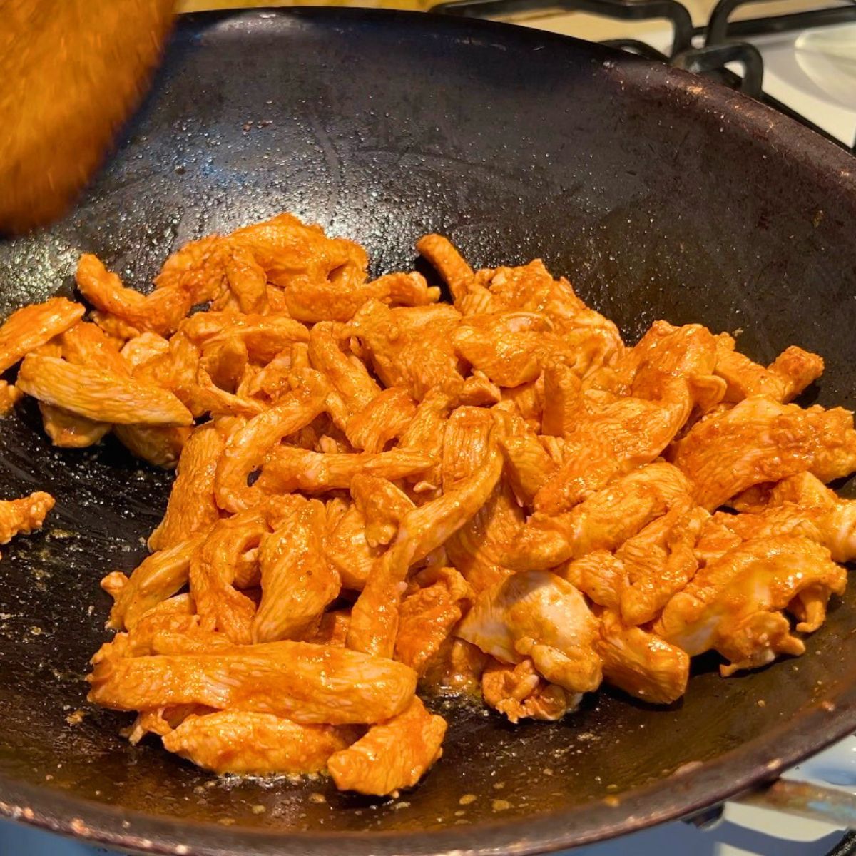 Cooking chicken with taco seasoning in skilet.