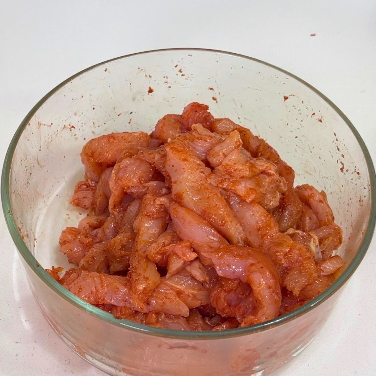 A bowl with chicken seasoned in taco seasoning.