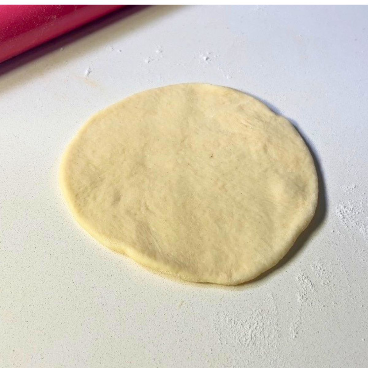 Dough rolled into a disc to fill with jam.