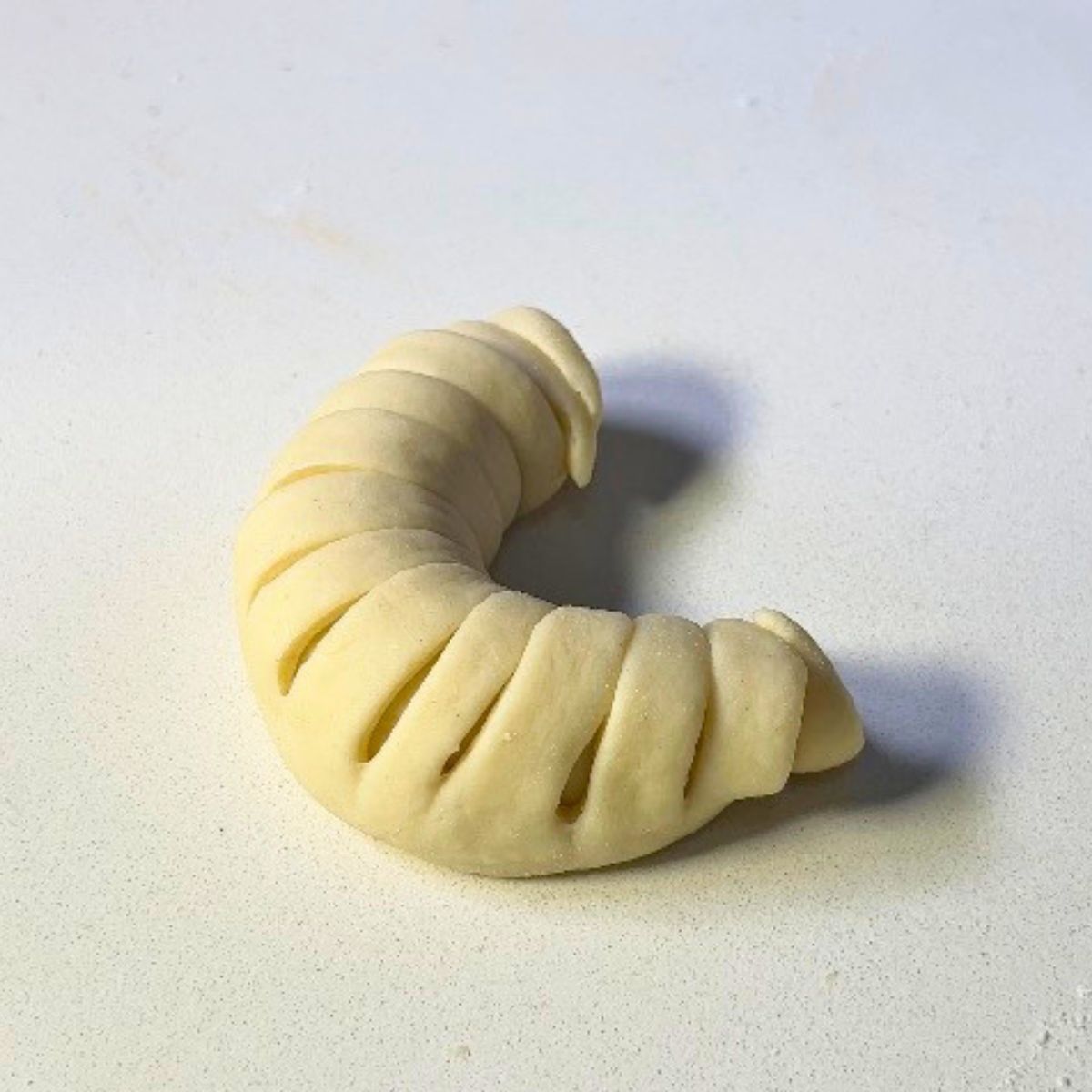 Crescent-shaped roll with jam for baking.