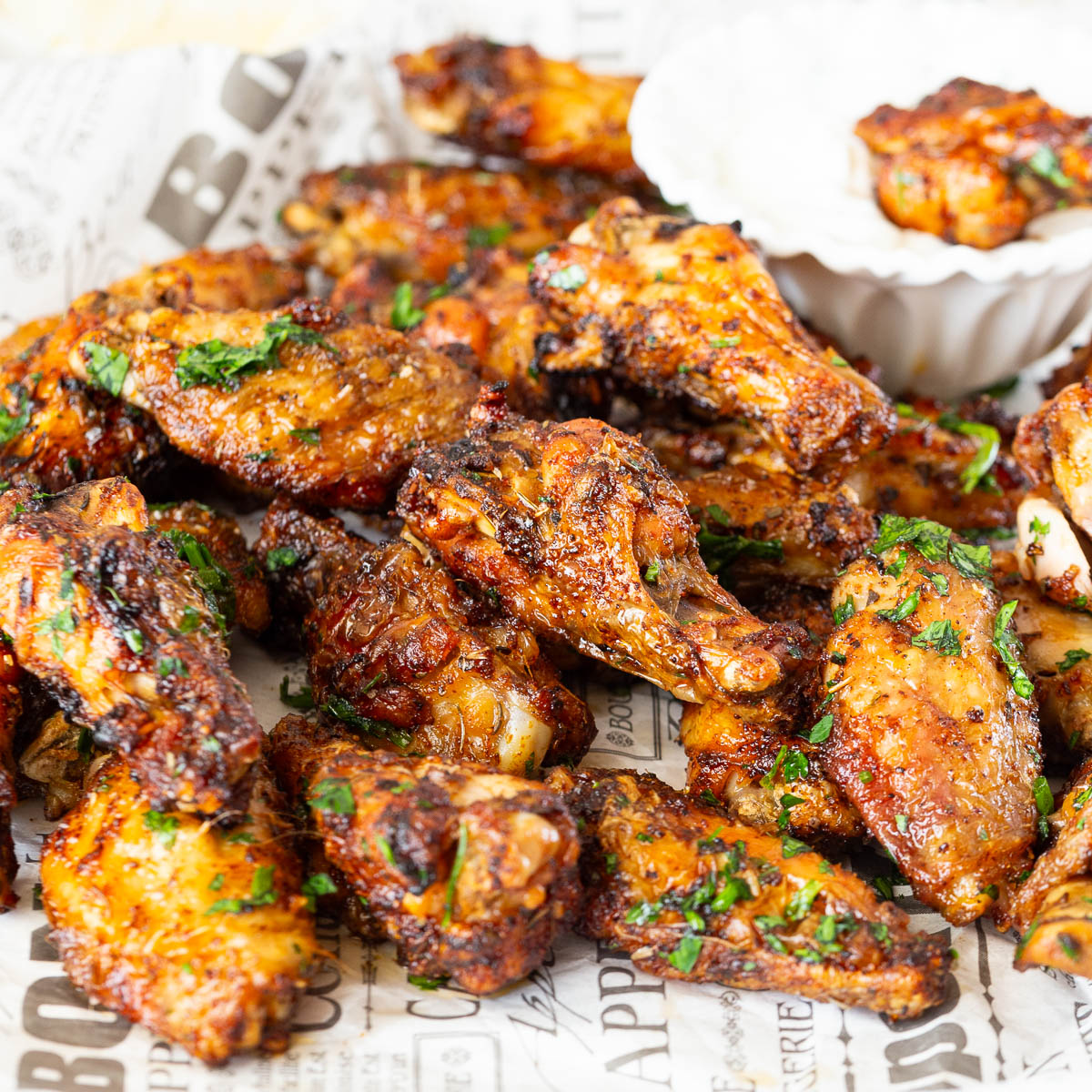Pie of baked chicken wings on news paper.