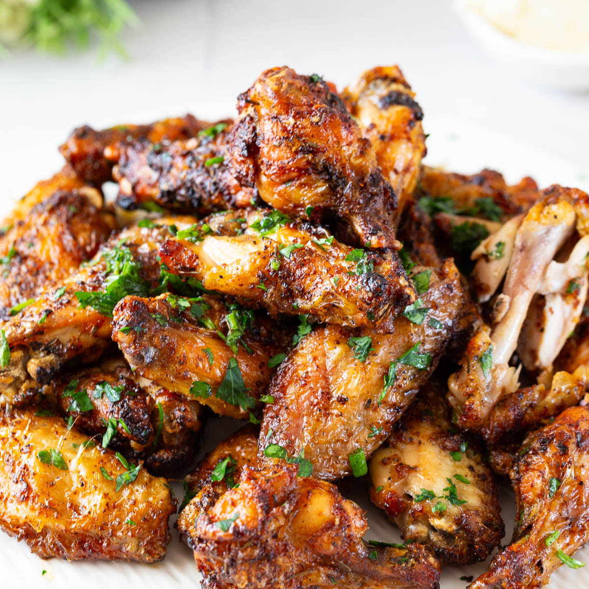 Lemon butter drizzled chicken wings on the plate.