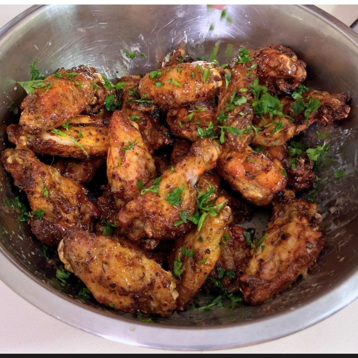 A bowl with baked chicken wings.