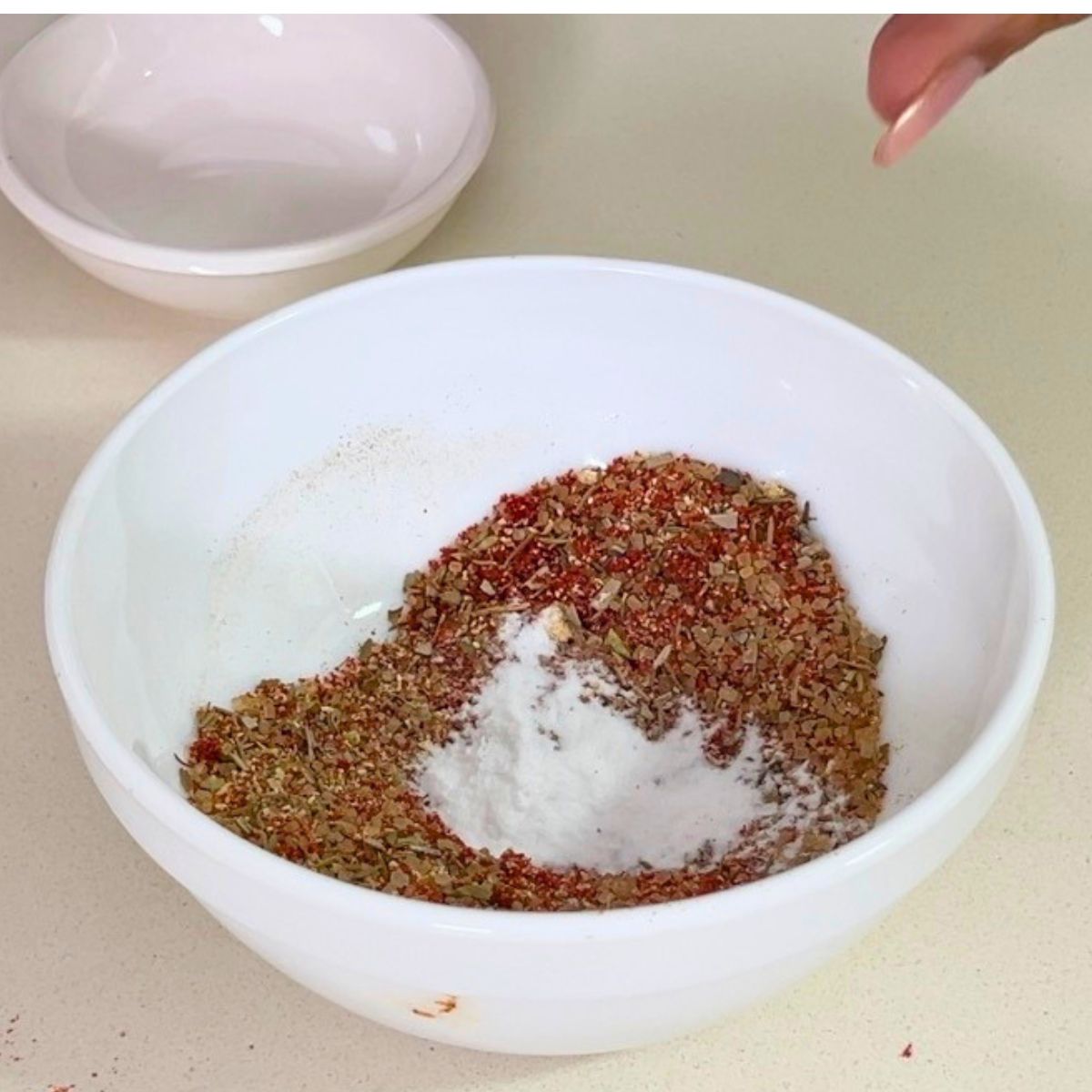 Creole seasoning in a small white bowl.