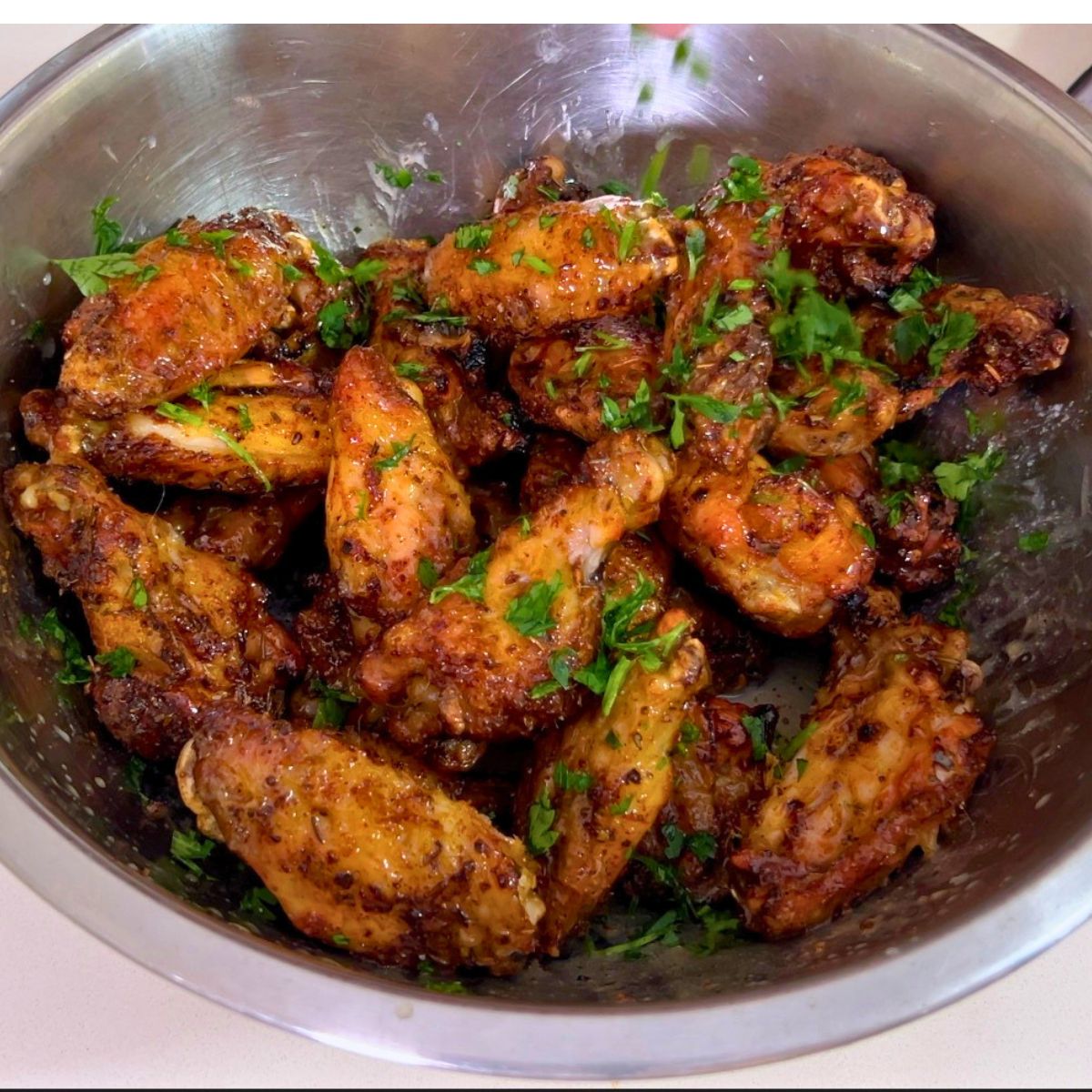 A bowl with chicken wings with lemon butter.