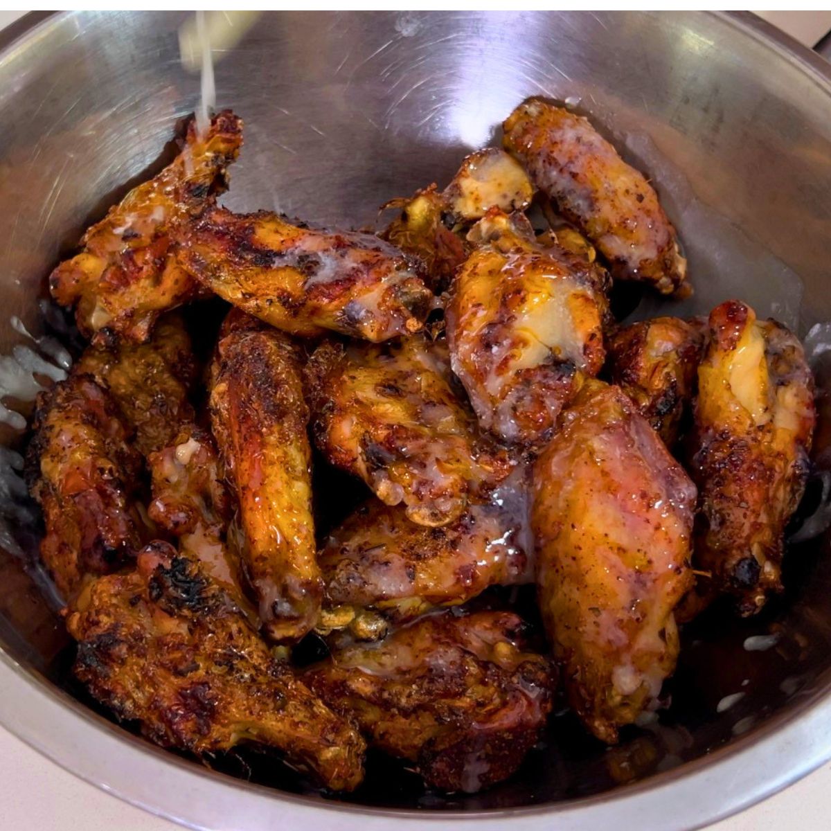 A bowl with baked chicken wings.