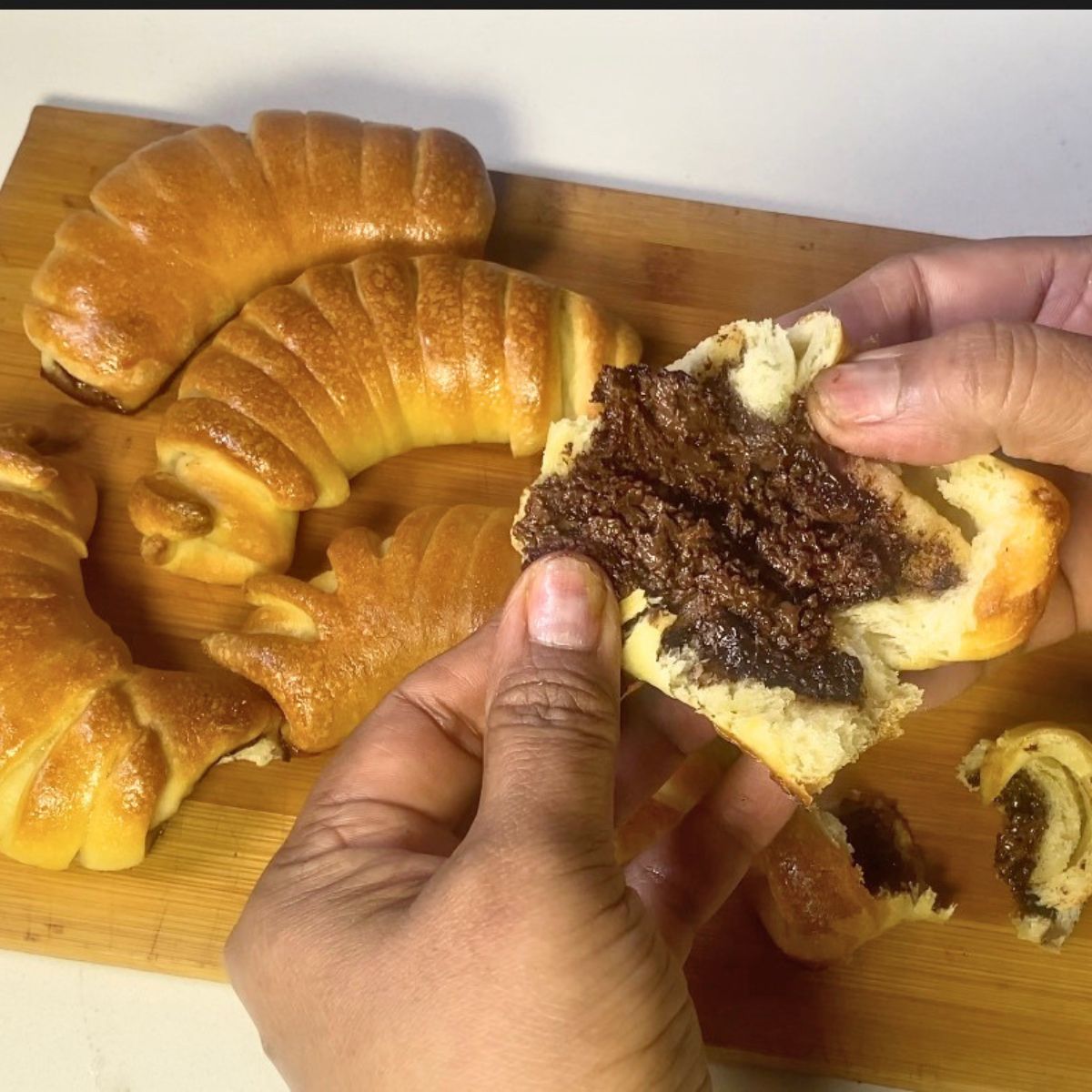 Torn up Nutella bun showing the chocolate spread inside.