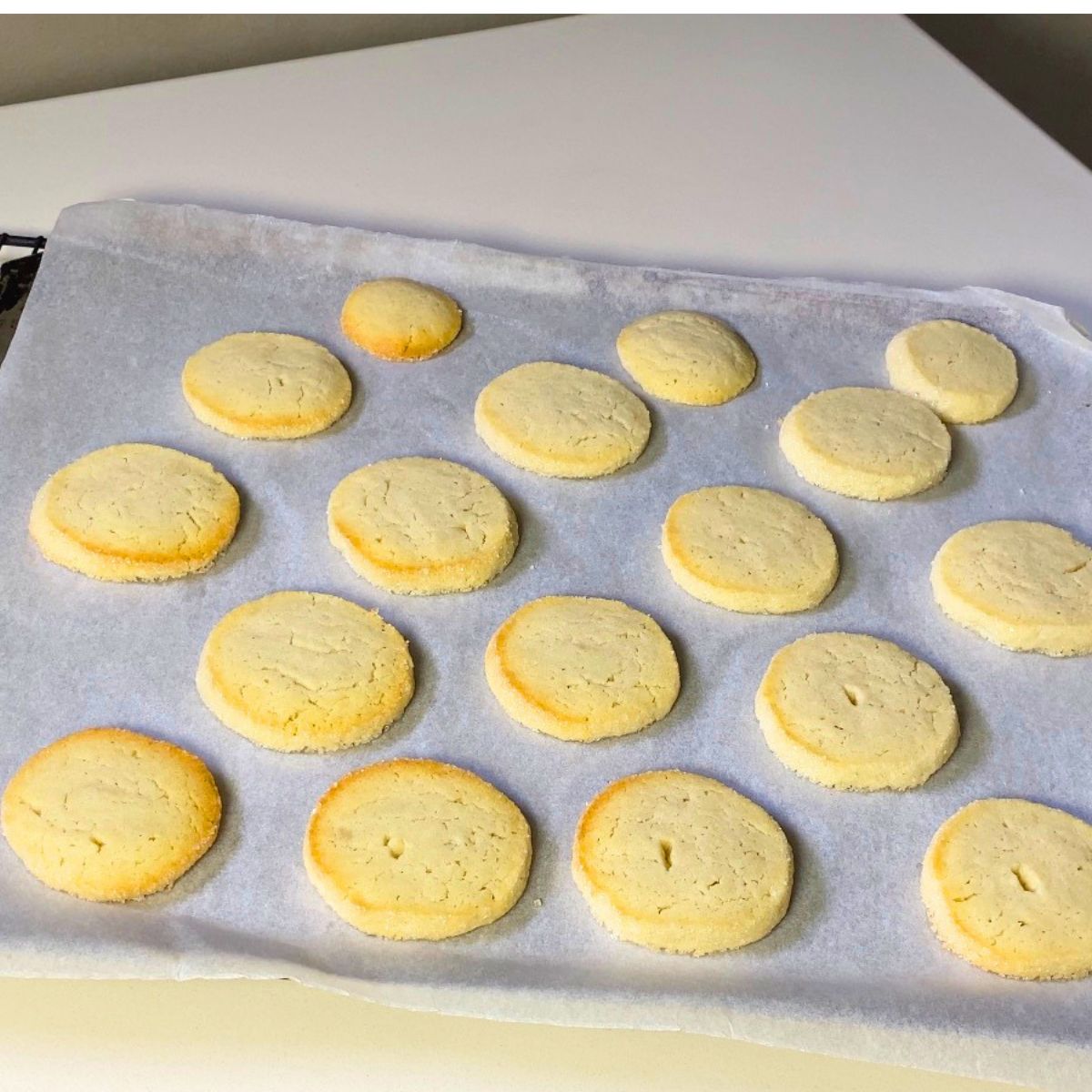 Fresh baked butter cookies on a baking sheet.