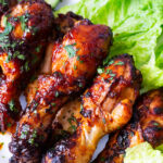 Air fryer baked chicken legs on lettuce.