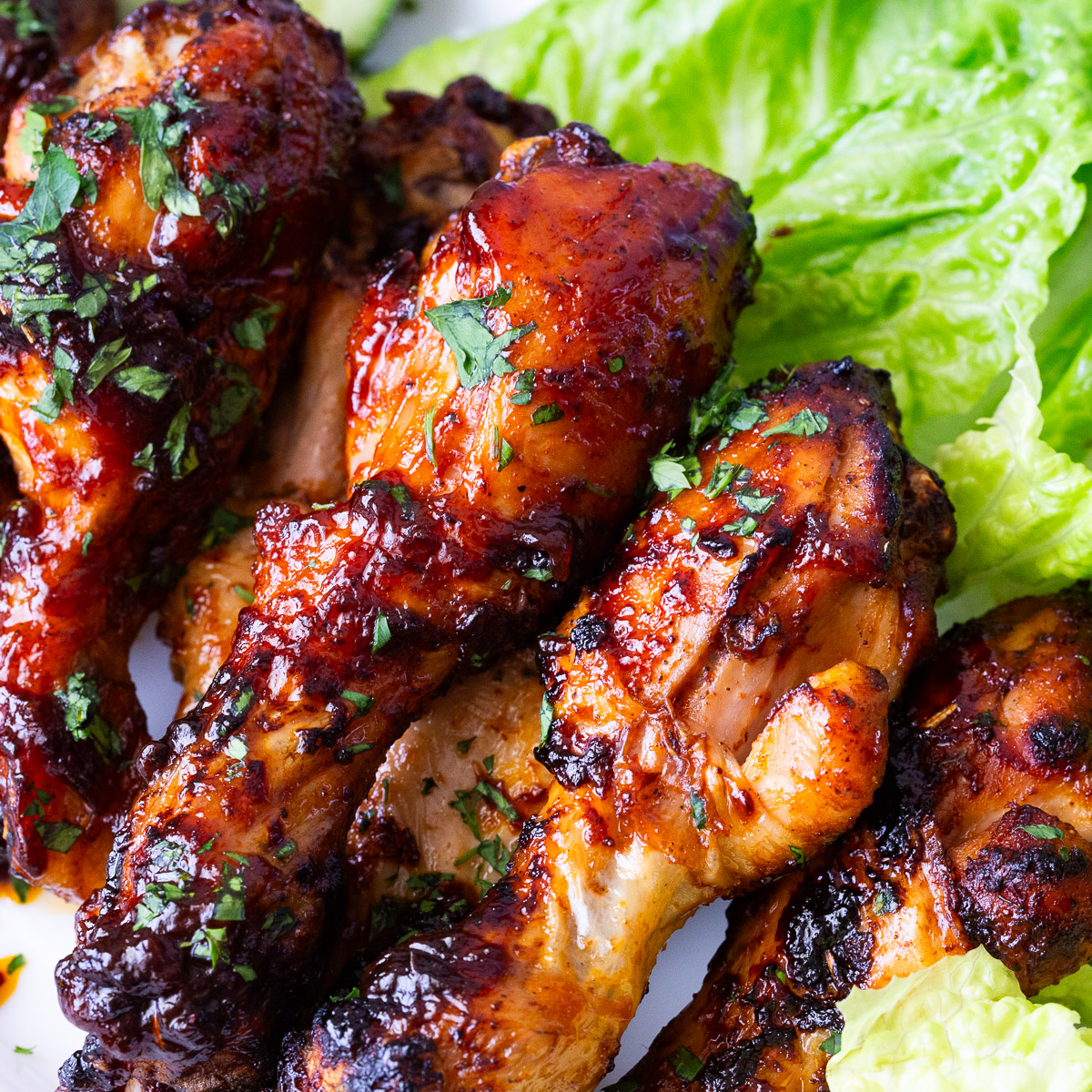 Air fryer baked chicken legs on lettuce.