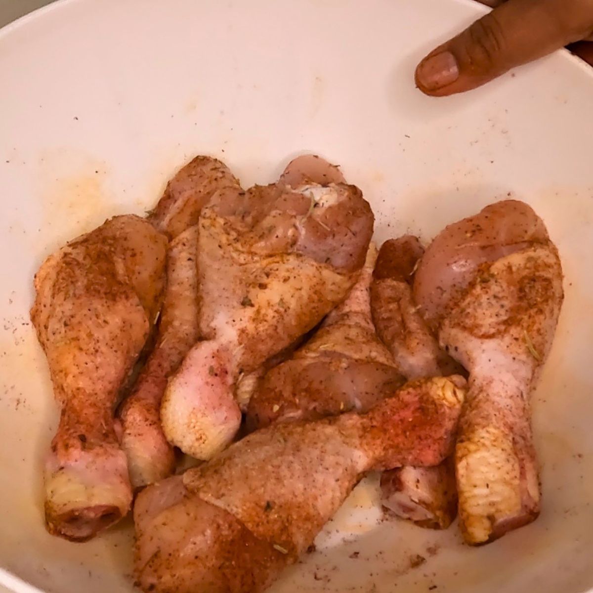 A basket with seasoned chicken legs.