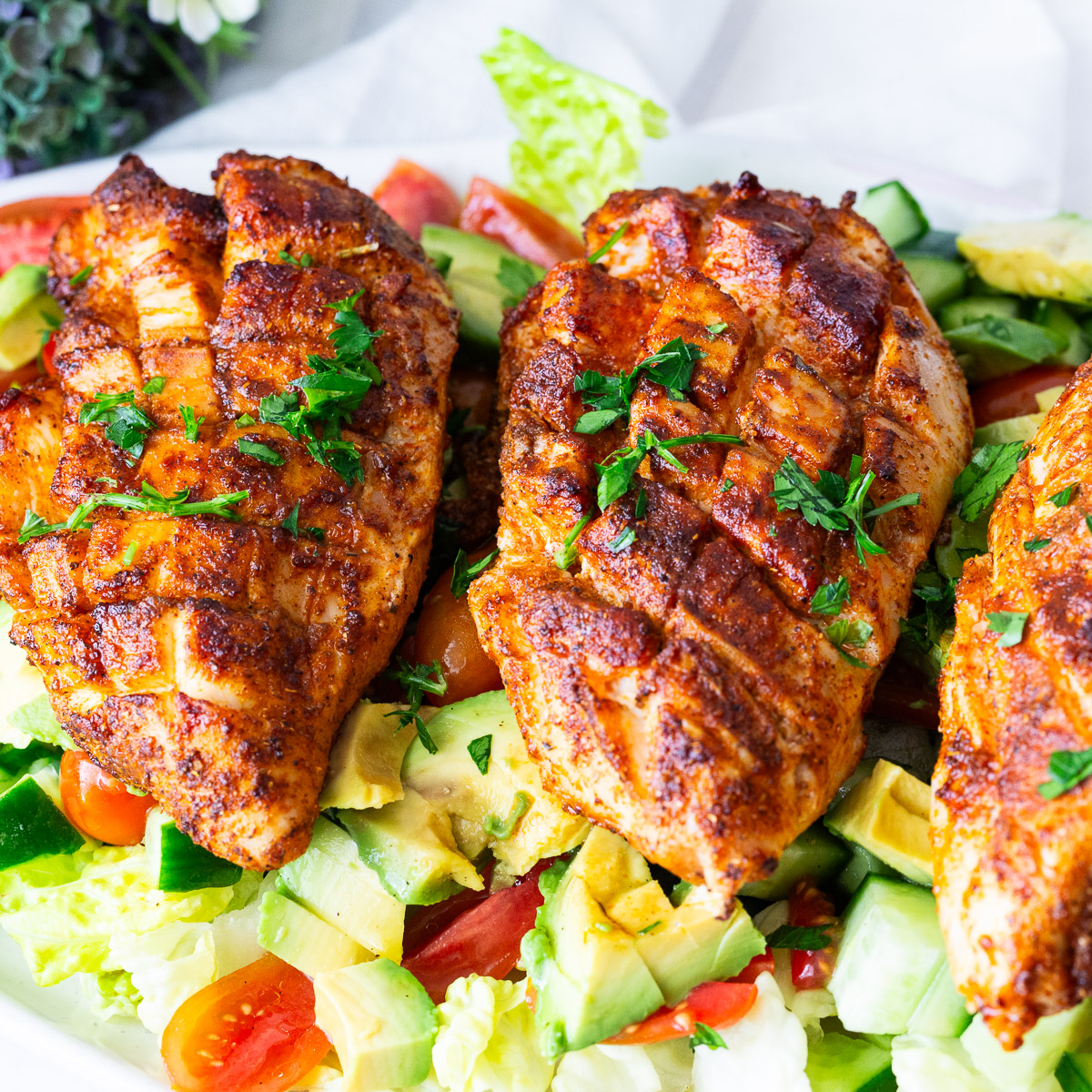 Chicken breast over lettuce salad.