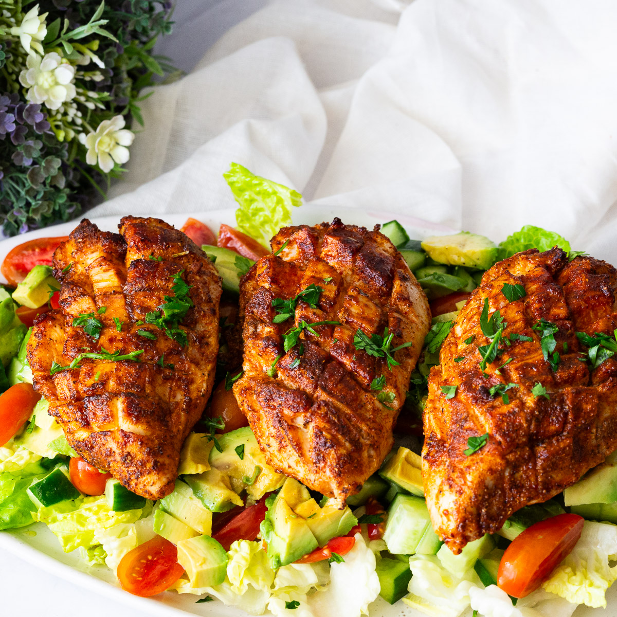 Chicken breast over fresh lettuce salad.