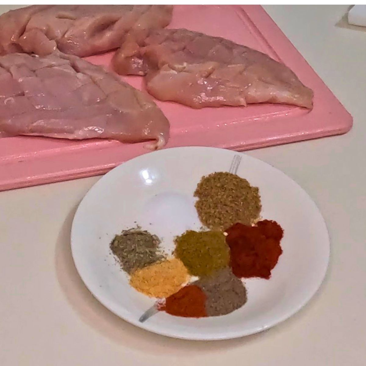 A saucer with spice and herbs for chicken breast.