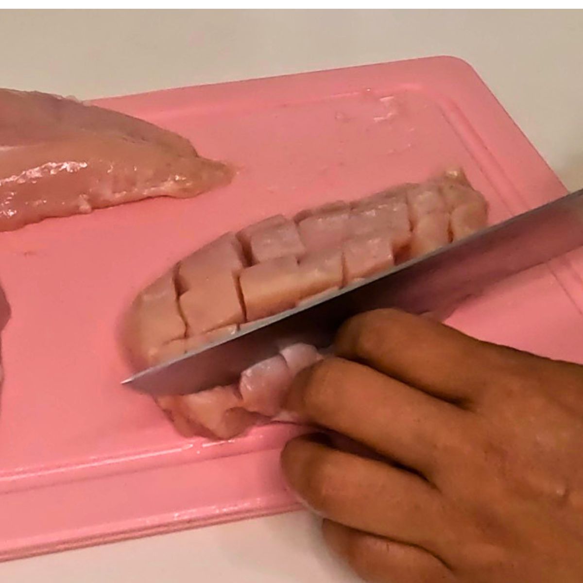 Scoring the chicken breast for baking.