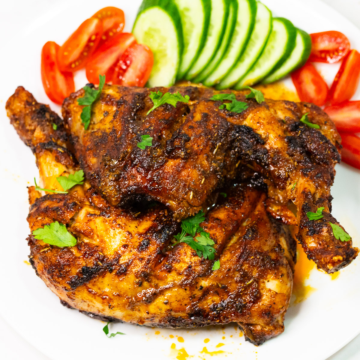 Baked chicken quarters on a plate.