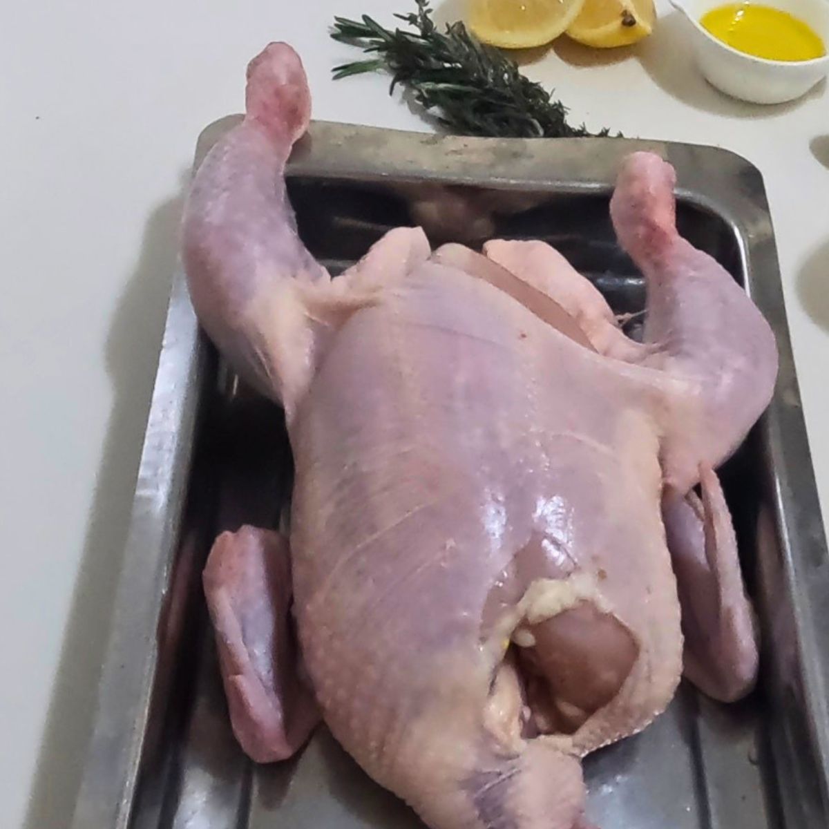 A whole roasting chicken on a tray.