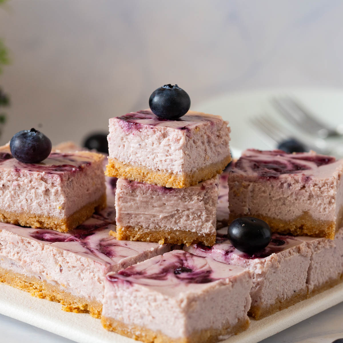 Stack of blueberry cheesecake bars.