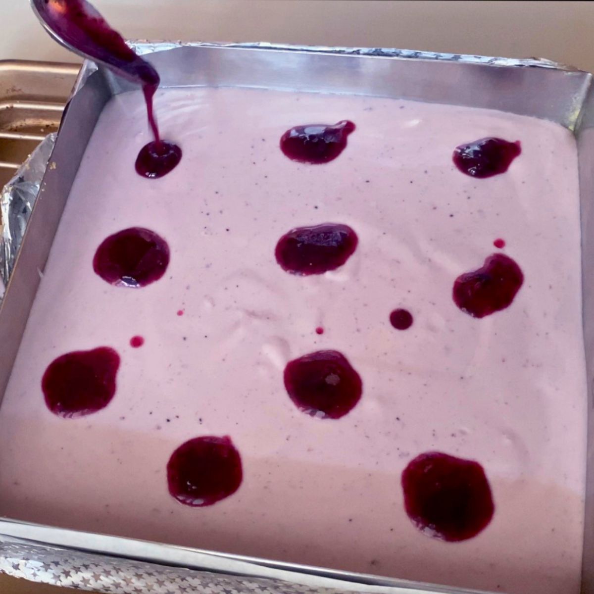 Blueberry puree dots for swirl on blueberry cheesecake batter.