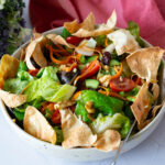 A bowl with fresh butter lettuce salad and veggies.