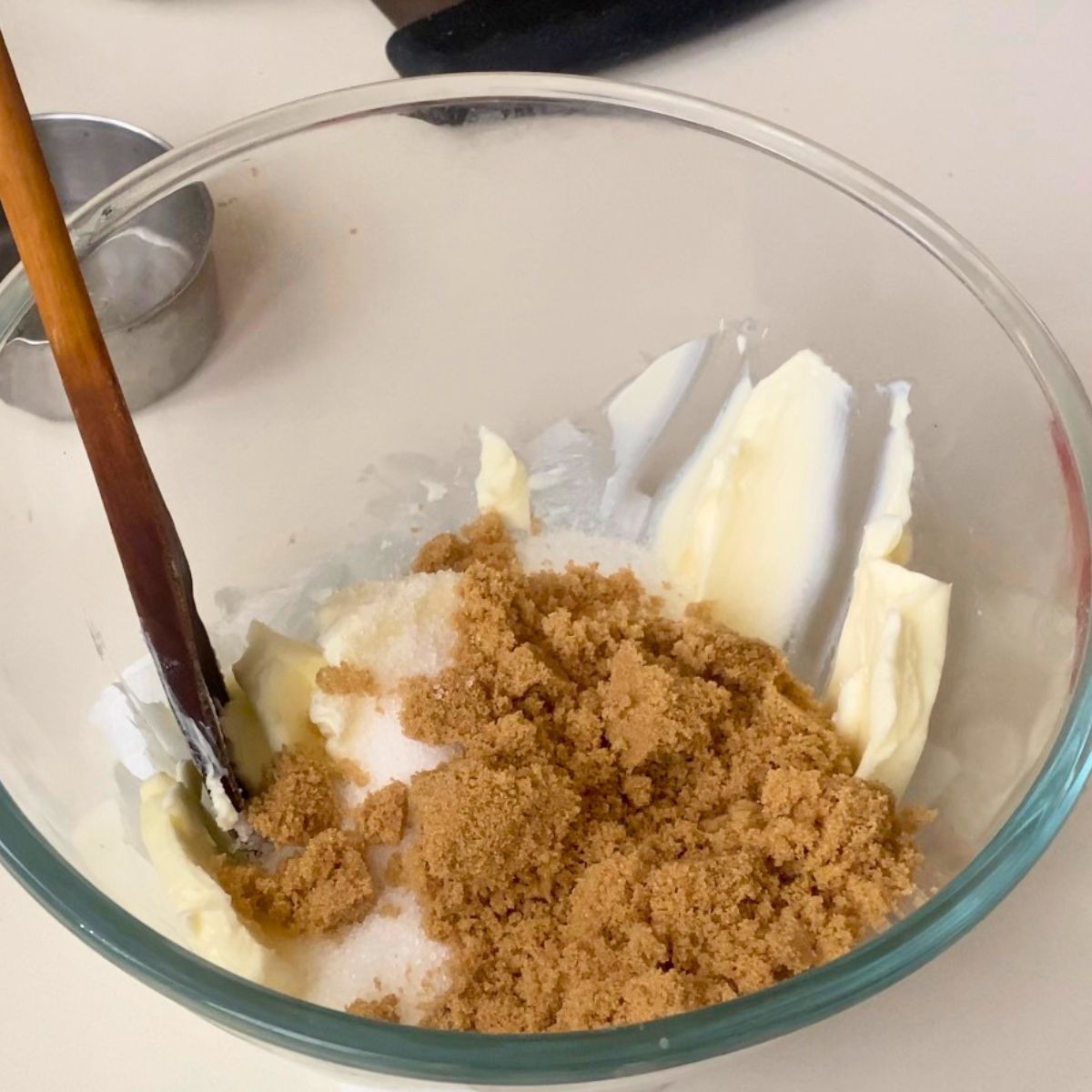Creaming butter and sugars in glass bowl.